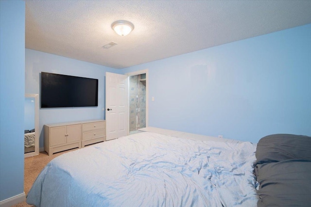 bedroom featuring light colored carpet and a textured ceiling