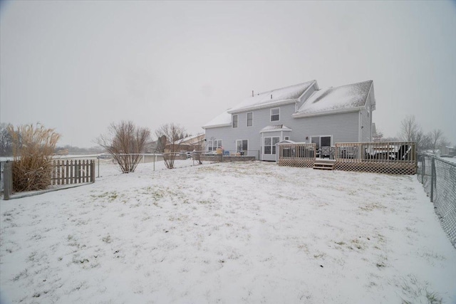 snow covered rear of property featuring a wooden deck