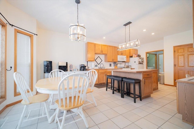 tiled dining space with a chandelier and sink