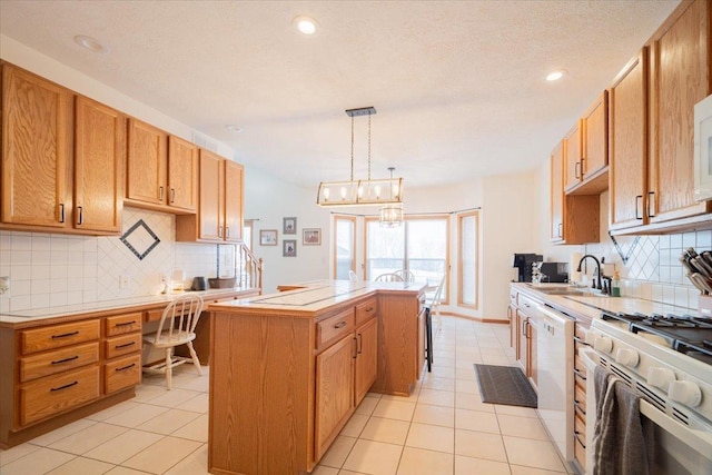 kitchen with white appliances, pendant lighting, a center island, an inviting chandelier, and sink