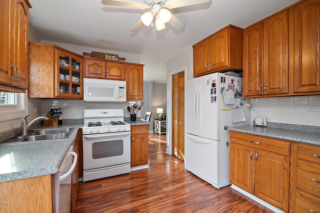 kitchen featuring tasteful backsplash, white appliances, ceiling fan, dark wood-type flooring, and sink