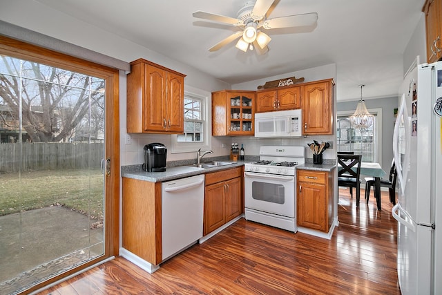 kitchen with decorative light fixtures, plenty of natural light, white appliances, and sink