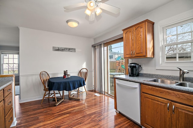 kitchen with decorative backsplash, white dishwasher, ceiling fan, sink, and dark hardwood / wood-style floors