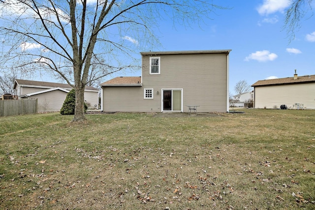 rear view of house featuring a yard