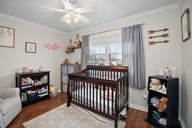 bedroom featuring dark hardwood / wood-style floors, a nursery area, ornamental molding, and ceiling fan