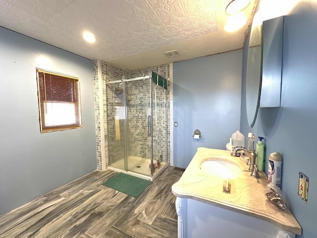 bathroom with hardwood / wood-style flooring, vanity, and an enclosed shower