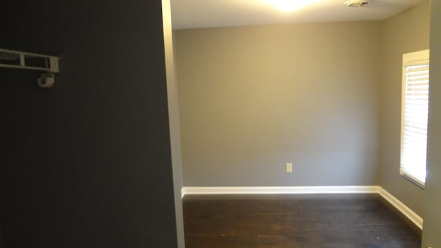 unfurnished room with dark wood-type flooring