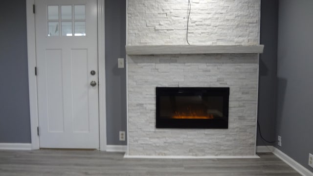 interior details featuring a stone fireplace and hardwood / wood-style floors