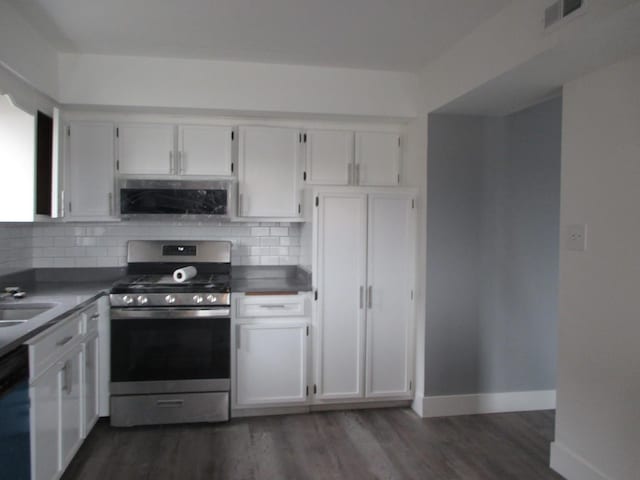 kitchen with appliances with stainless steel finishes, tasteful backsplash, and white cabinetry