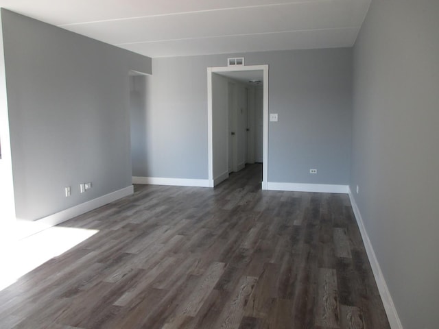 unfurnished room with dark wood-type flooring