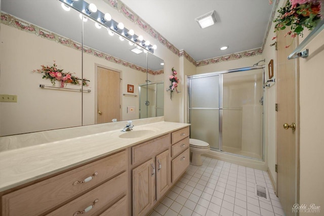 bathroom with tile patterned flooring, vanity, toilet, and walk in shower