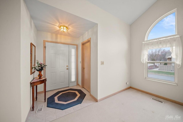 carpeted foyer entrance featuring vaulted ceiling