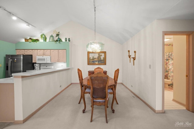 dining space with an inviting chandelier, light colored carpet, vaulted ceiling, and rail lighting