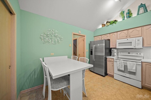 kitchen with stainless steel refrigerator with ice dispenser, stove, light brown cabinetry, tasteful backsplash, and lofted ceiling