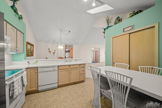 kitchen featuring pendant lighting, light brown cabinets, white appliances, sink, and vaulted ceiling with skylight