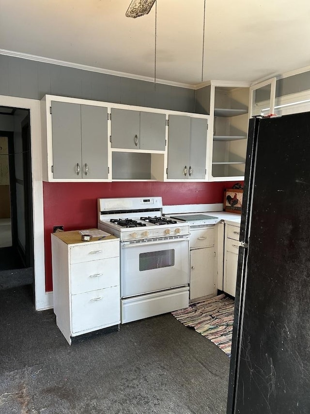 kitchen with black refrigerator, crown molding, and white gas stove