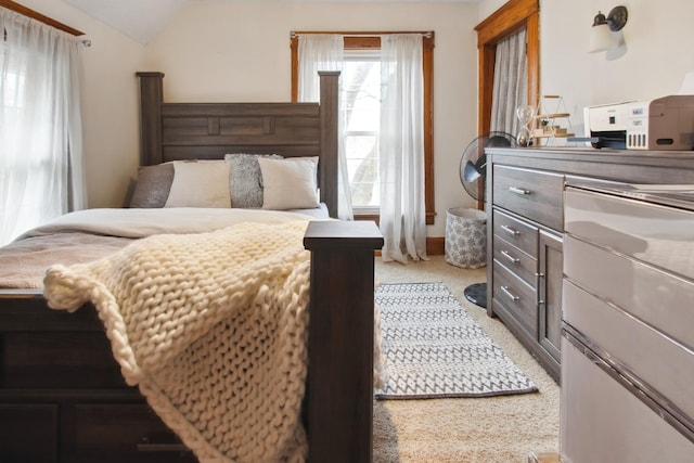 bedroom with light colored carpet and lofted ceiling