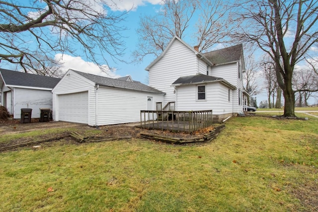 rear view of house with a yard, a garage, an outdoor structure, and a wooden deck