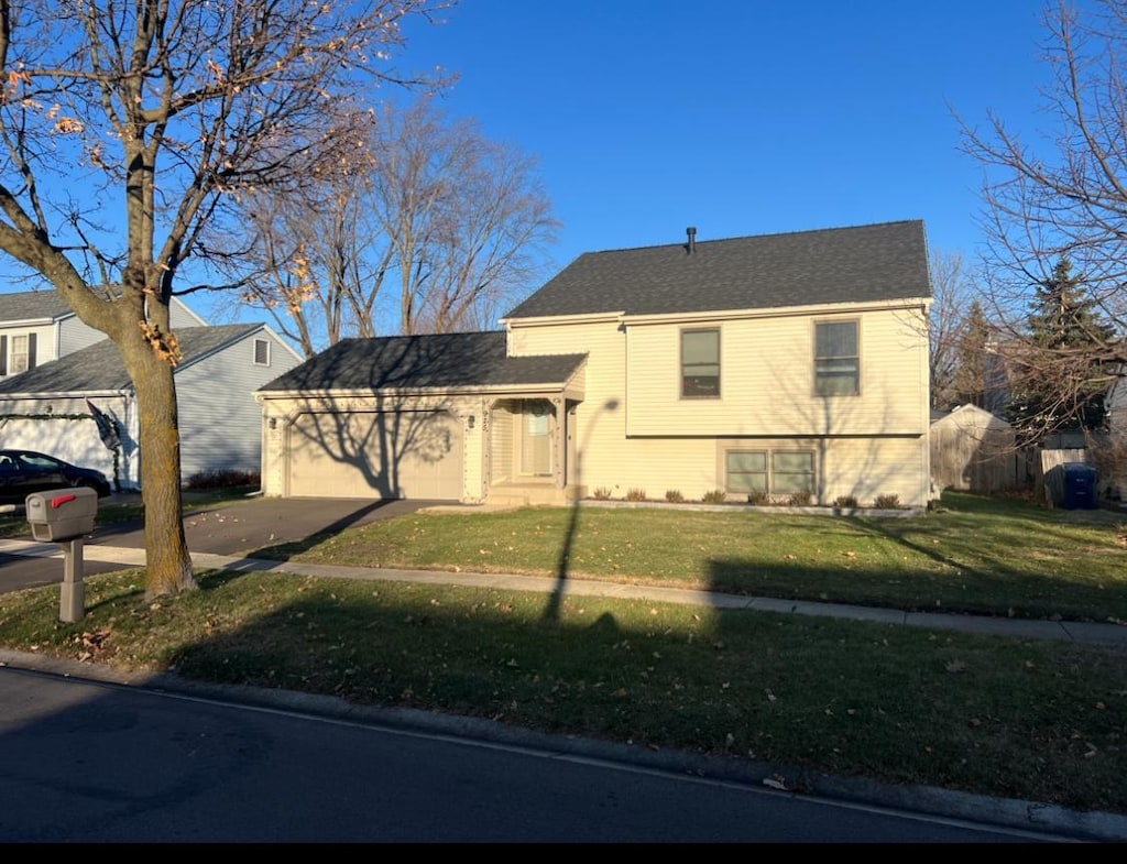 tri-level home featuring a front yard and a garage