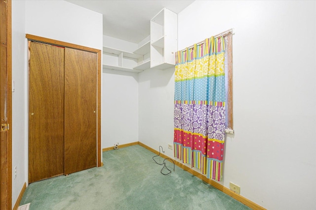 walk in closet with light carpet