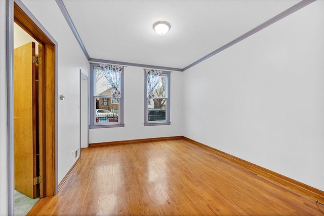 unfurnished room with light wood-type flooring and crown molding