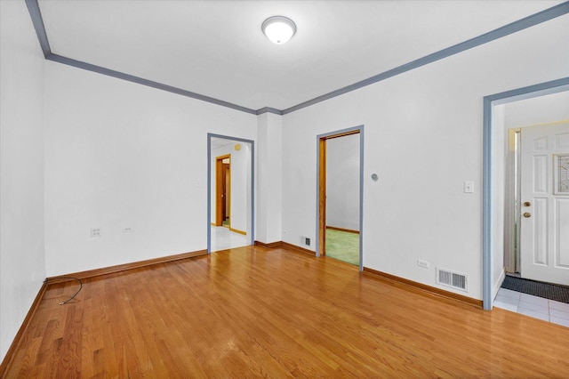 spare room with crown molding and hardwood / wood-style flooring