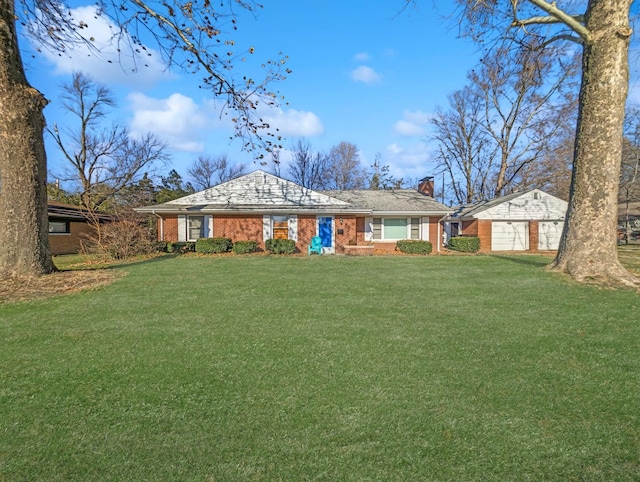 ranch-style home featuring a garage, an outdoor structure, and a front lawn