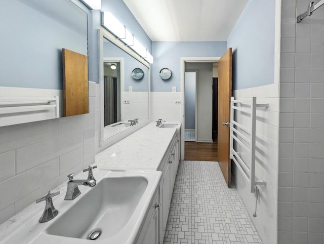 bathroom featuring vanity and tile walls