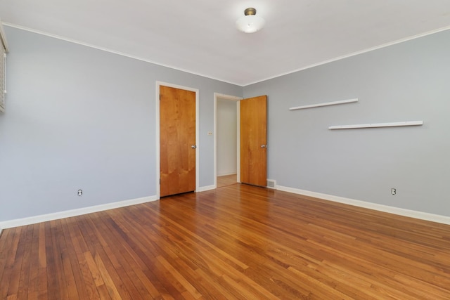 empty room with crown molding and hardwood / wood-style floors