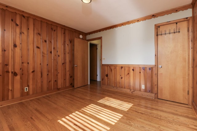 unfurnished room featuring crown molding and light wood-type flooring