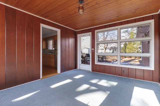 unfurnished sunroom with wood ceiling and sink