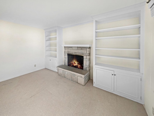 unfurnished living room with light colored carpet, built in features, and a fireplace