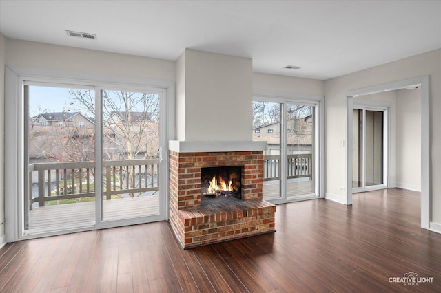 living room with plenty of natural light, dark hardwood / wood-style floors, and a brick fireplace