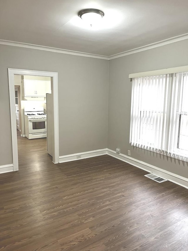 empty room with dark hardwood / wood-style floors and ornamental molding