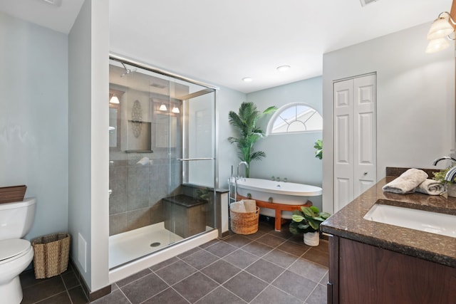 full bathroom with a stall shower, toilet, tile patterned floors, vanity, and a freestanding tub