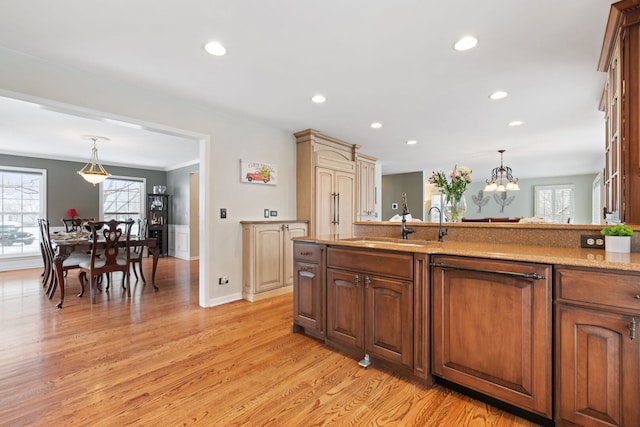 kitchen with light wood-style floors, recessed lighting, decorative light fixtures, and a sink