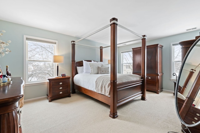 bedroom featuring baseboards, visible vents, and light colored carpet