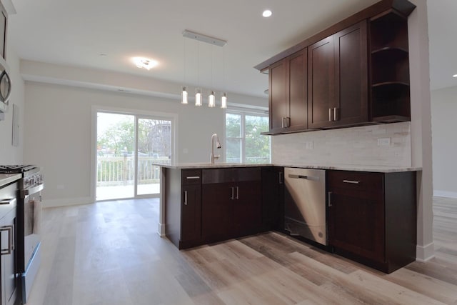 kitchen with kitchen peninsula, light hardwood / wood-style floors, decorative light fixtures, and appliances with stainless steel finishes