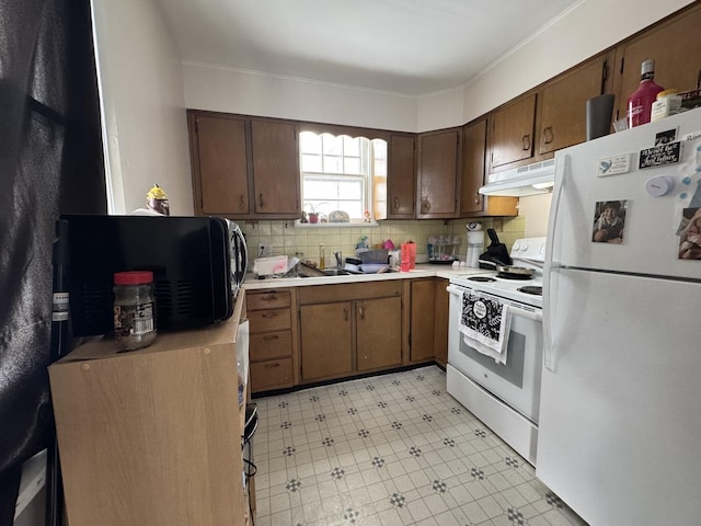 kitchen featuring dark brown cabinetry, sink, backsplash, white appliances, and ornamental molding