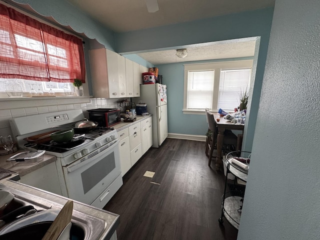 kitchen featuring decorative backsplash, white cabinetry, dark hardwood / wood-style flooring, and white appliances