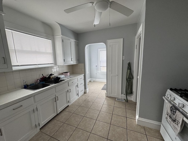 kitchen featuring white cabinets, a healthy amount of sunlight, and white gas range oven