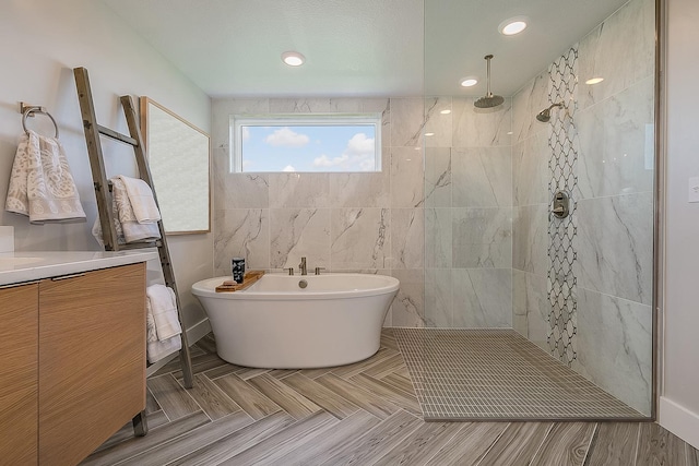 bathroom with separate shower and tub, vanity, and tile walls