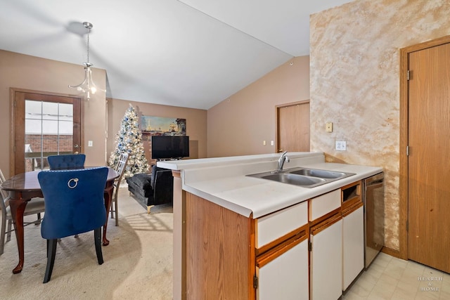 kitchen with kitchen peninsula, lofted ceiling, hanging light fixtures, stainless steel dishwasher, and sink