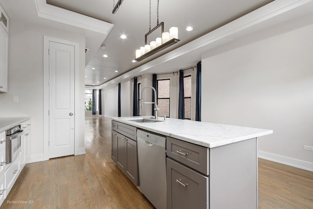 kitchen with dishwasher, sink, oven, and an island with sink