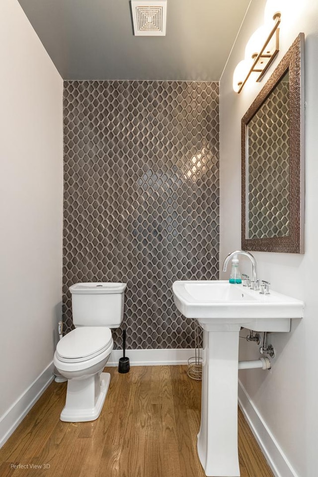 bathroom with hardwood / wood-style floors and toilet