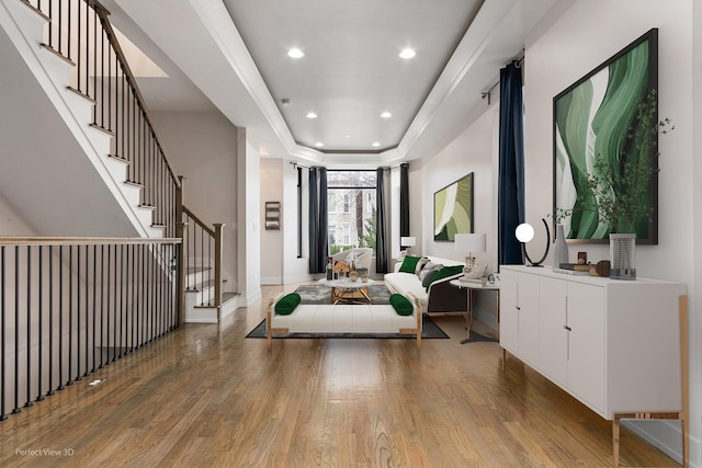 foyer with wood-type flooring and a raised ceiling