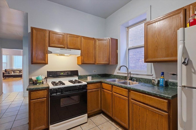 kitchen with white appliances, sink, and light tile patterned floors