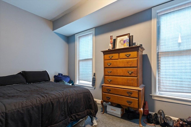 bedroom featuring multiple windows and light carpet