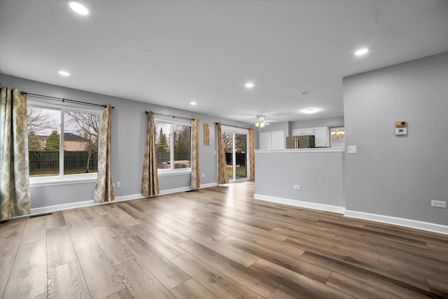 unfurnished living room featuring ceiling fan, plenty of natural light, and light wood-type flooring