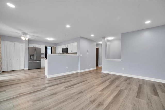 unfurnished living room featuring ceiling fan and light hardwood / wood-style floors